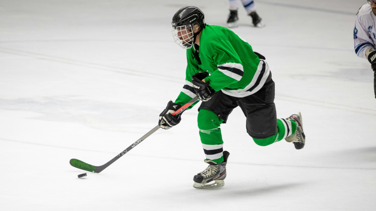 Myles Mint signals to pull the goalie in a tense hockey game with the crowd reacting
