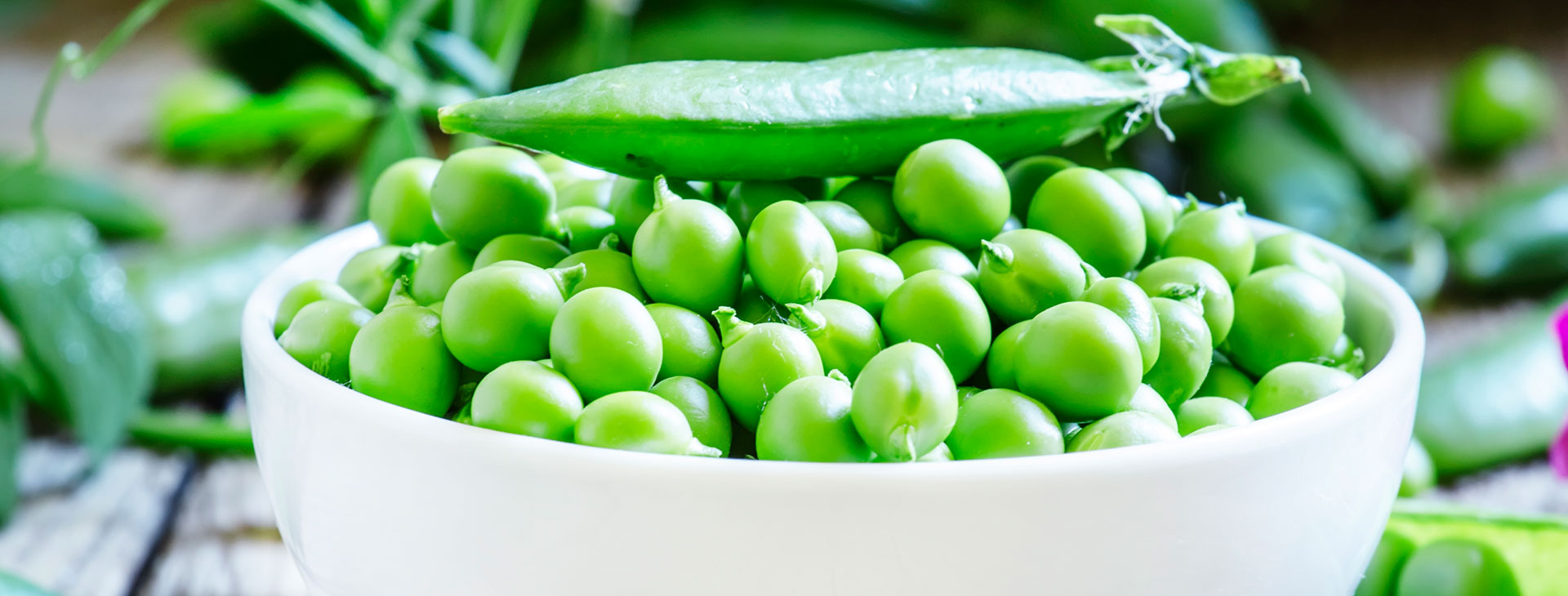 Fresh green peas in a wooden bowl ready for cooking
